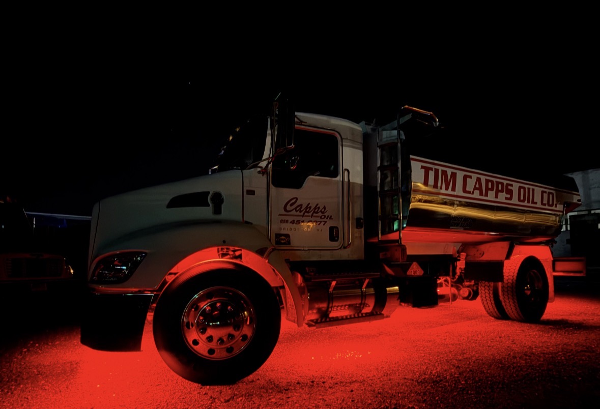 Tim Capps Oil Co. tank truck lit at night in the Bridgeton, NJ yard