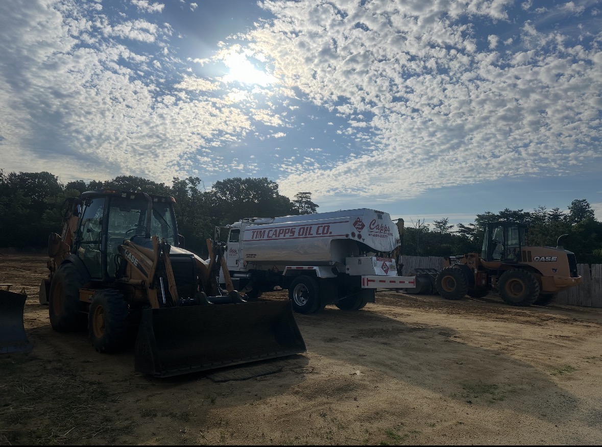 Tim Capps Oil Co. truck delivering fuel to CASE equipment on an open site