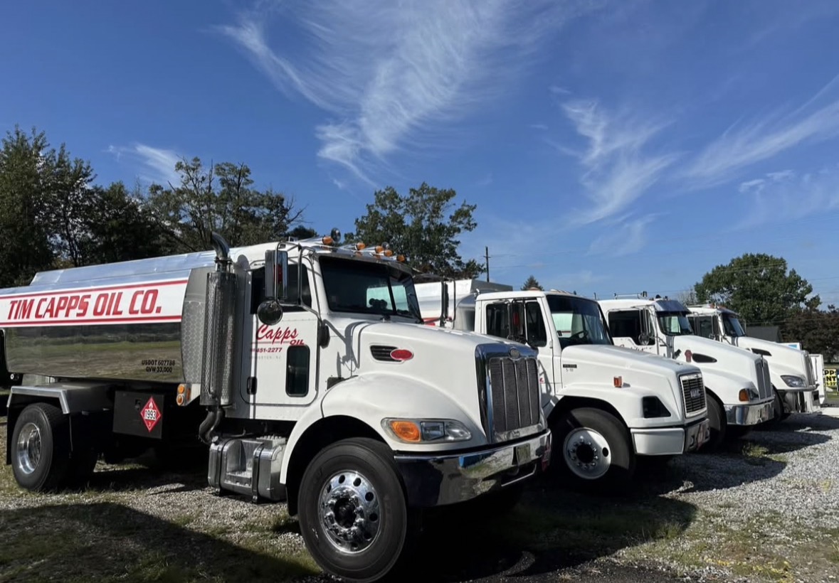 Tim Capps Oil Co. fuel delivery trucks lined up under a blue sky
