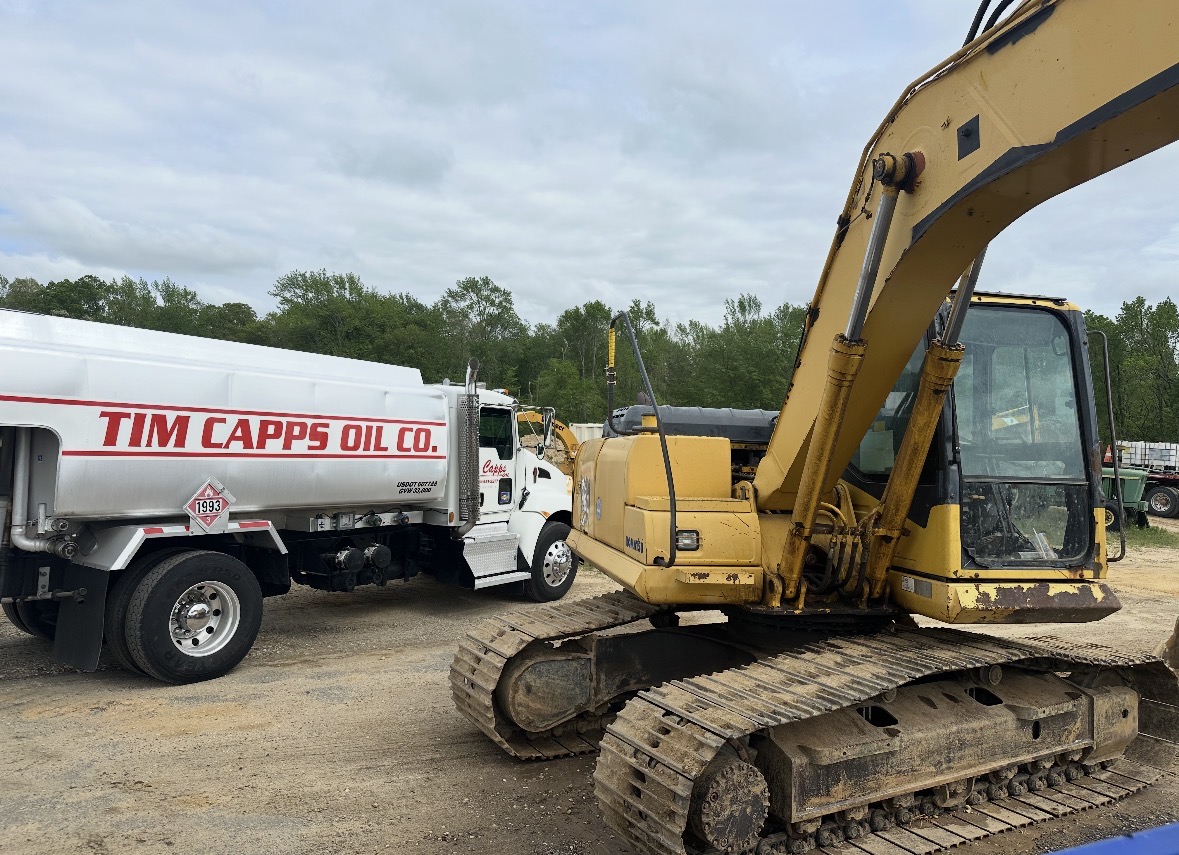 Tim Capps Oil Co. tank truck alongside a tracked excavator on a job site