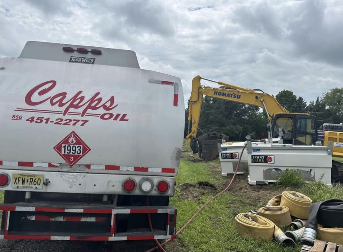 Tim Capps Oil Co. tanker fueling equipment beside a Komatsu excavator